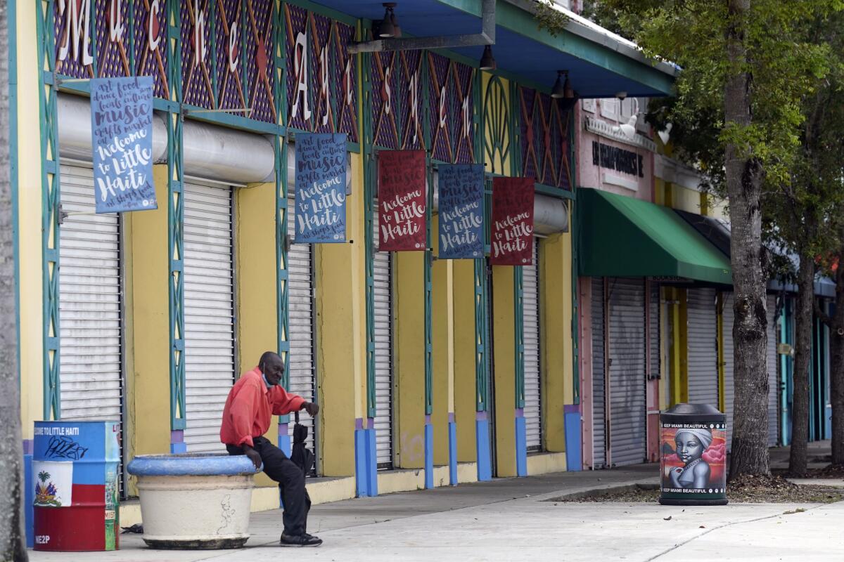 A man sits outside of the Little Haiti Cultural Center in the Little Haiti neighborhood of Miami, Wednesday, July 7, 2021, following the news that Haitian President Jovenel Moïse was assassinated in an attack on his private residence. (AP Photo/Lynne Sladky)