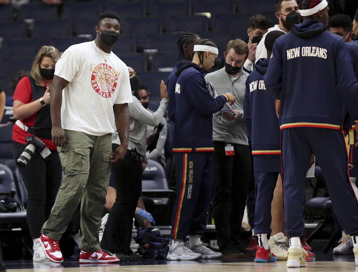 New Orleans Pelicans forward Zion Williamson, front left, watches from the sideline in the first half of an NBA preseason basketball game against the Minnesota Timberwolves, Monday, Oct. 4, 2021, in Minneapolis. (AP Photo/Andy Clayton-King)