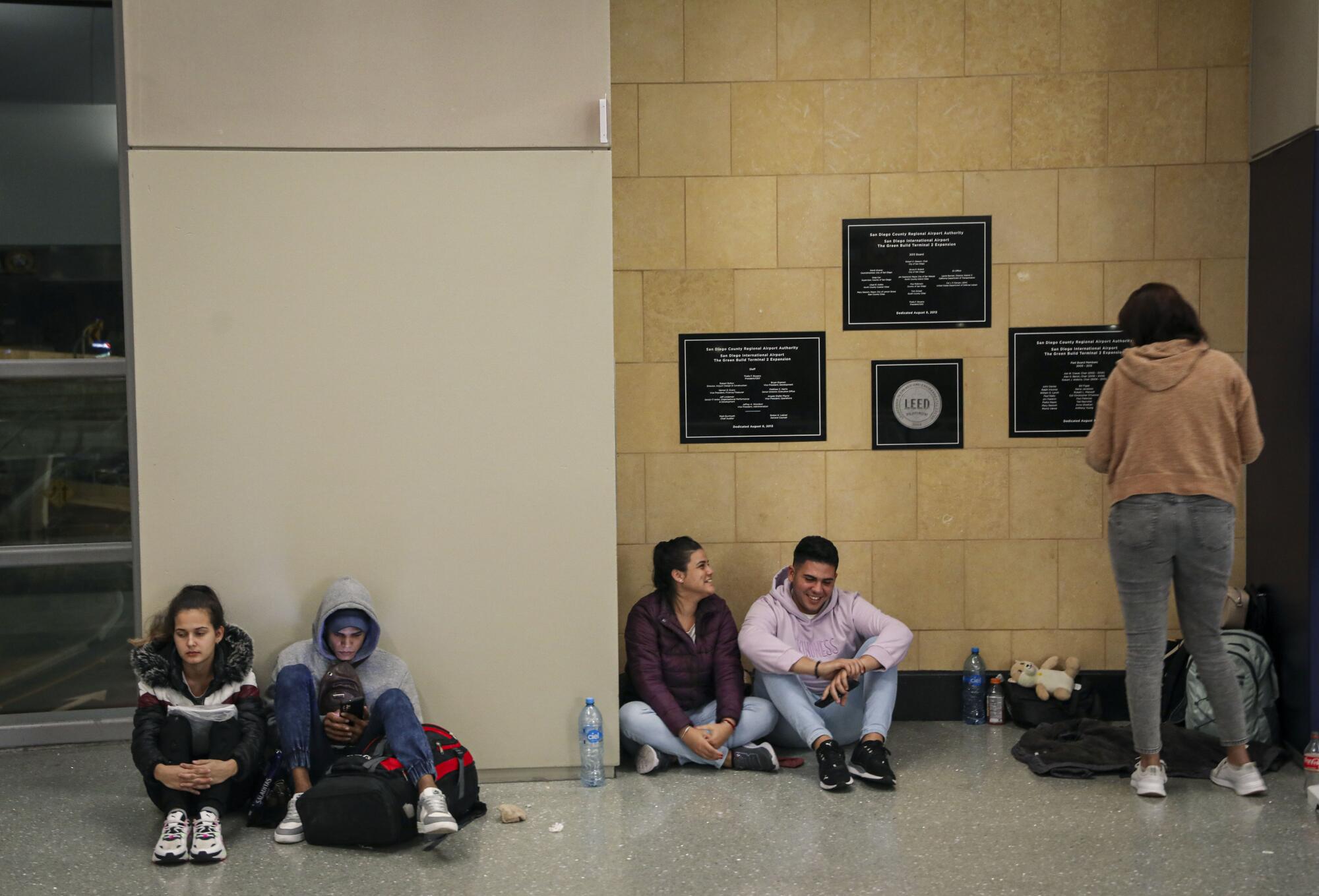 The Piovet family, from Cuba, sits at the San Diego International Airport Friday night.