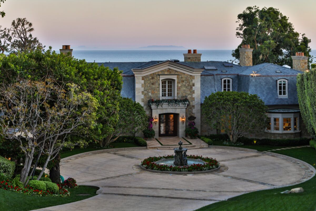 The French Regency-style residence sits on a 1.7-acre bluff in Malibu with two guest houses, a tennis court and a swimming pool.