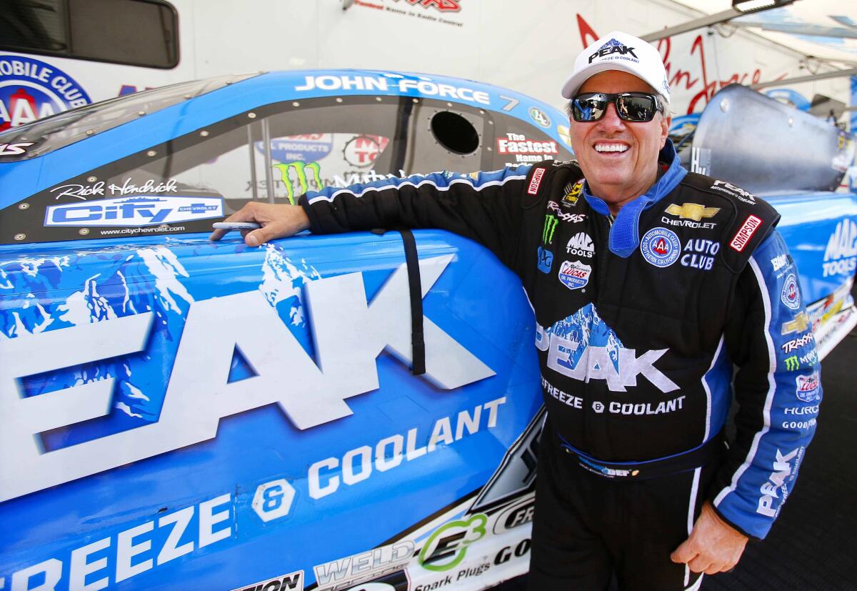John Force stands next to his Funny Car racer.