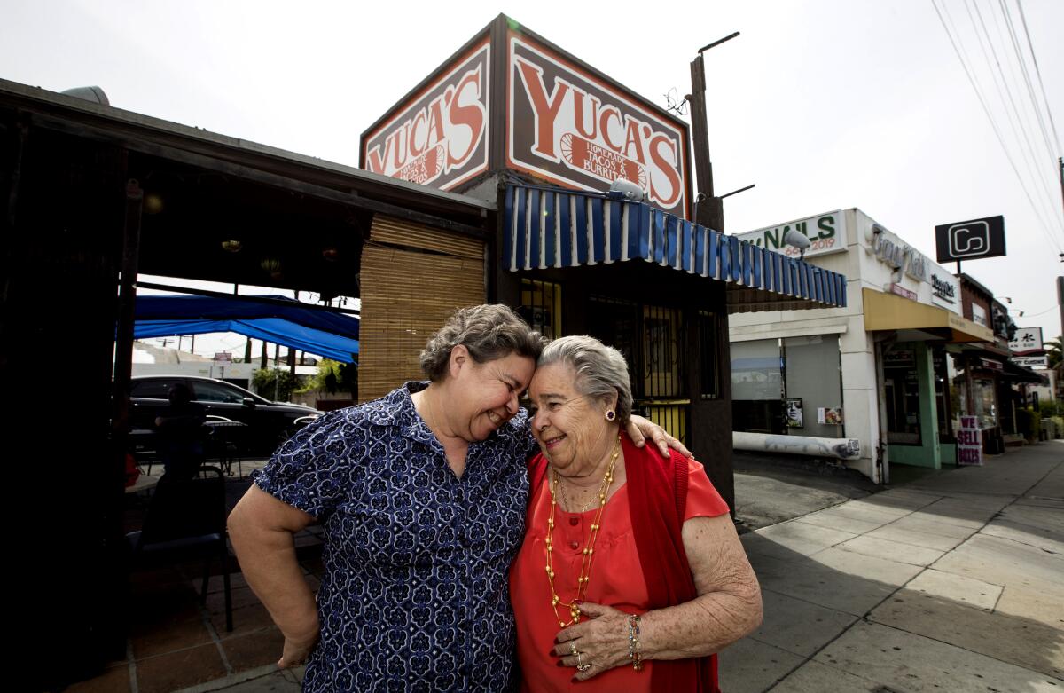 Two women hug in front of their family's restaurant
