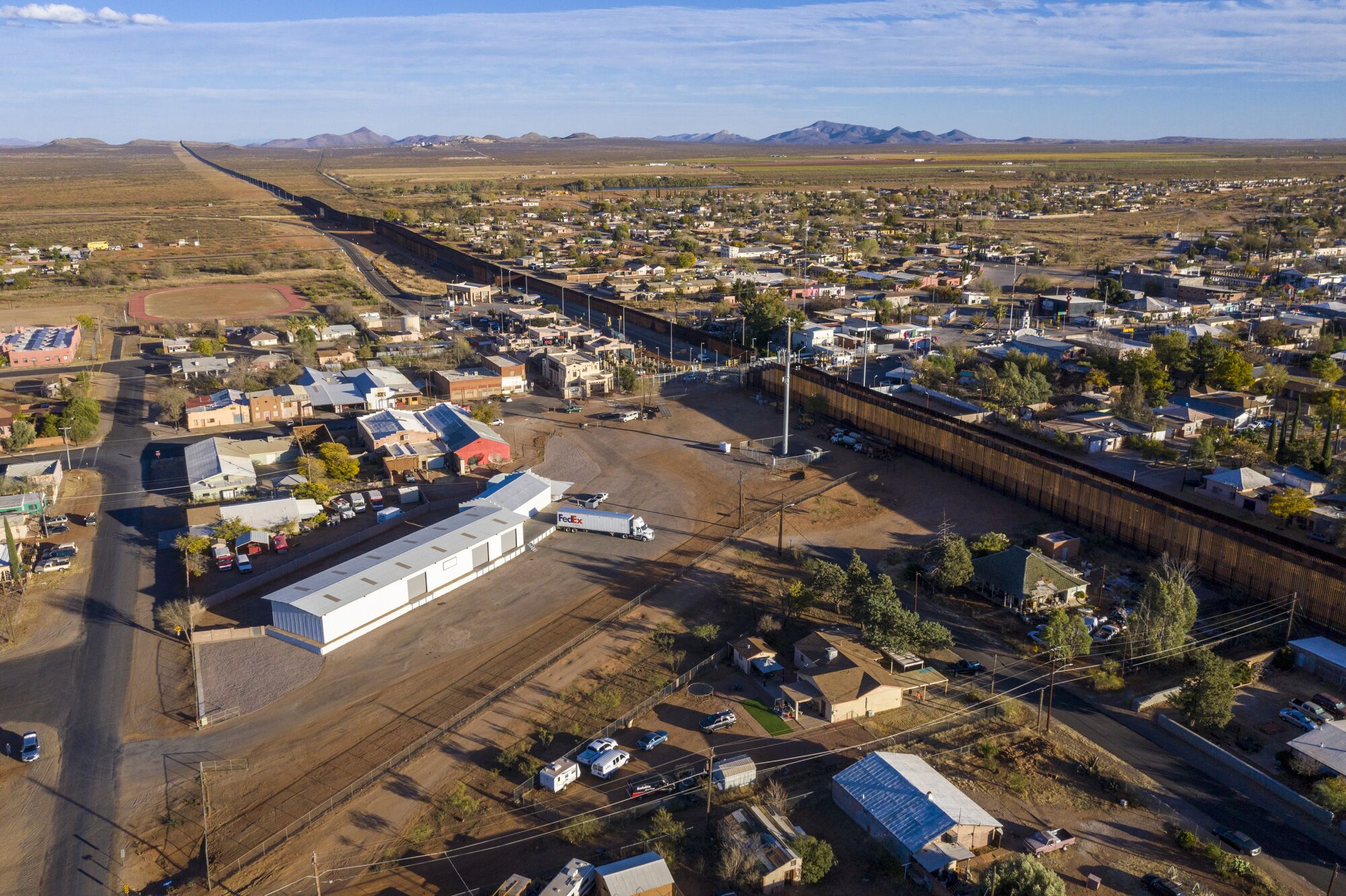 The Arizona town of Naco, left, and Sonora Mexico town of Naco, right, sit side by side, separated by the steel border wall.