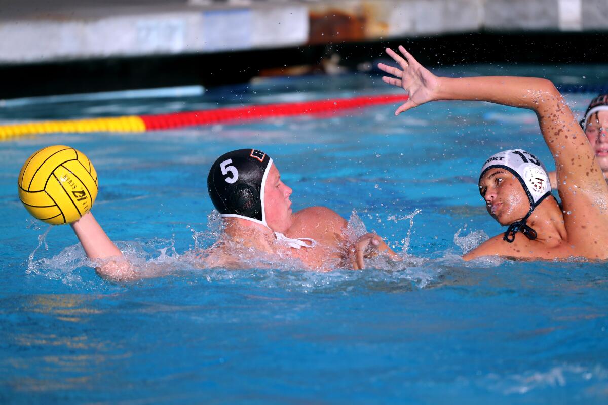 Newport Harbor High water polo player Ben Liechty pressures Chase Dodd, left, in a March 2021 game in Newport Beach.