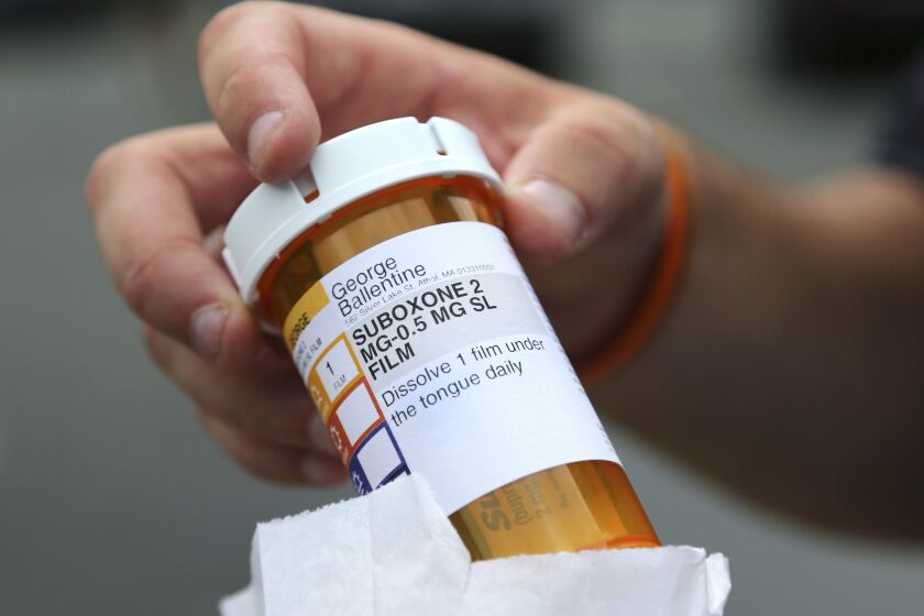 FILE - Newly-released inmate George Ballentine holds his prescription medicine Suboxone outside a pharmacy on July 23, 2018, in Greenfield, Mass. The attorneys general for 41 states and the District of Columbia announced a $102.5 million settlement Friday, June 2, 2023, with Suboxone maker Indivior Inc., over claims that the company schemed to keep generic competitors off the market. Suboxone, a branded version of buprenorphine and naloxone, is used to treat opioid addiction. (AP Photo/Elise Amendola)