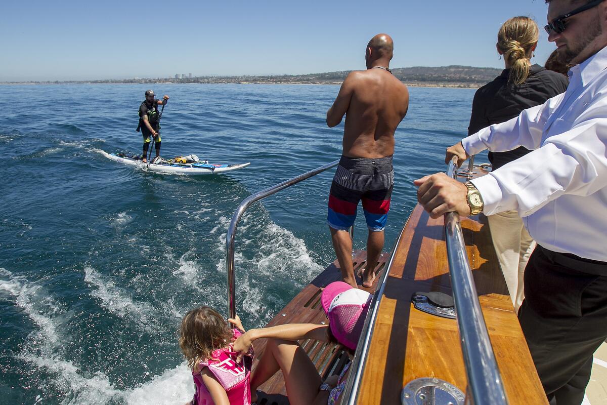 Friends and family watch from the Paradiso as Will Schmidt paddles off the coast of Newport Beach on Wednesday, July 23. Schmidt is paddling from Canada to Mexico to benefit the Wounded Warrior Project.