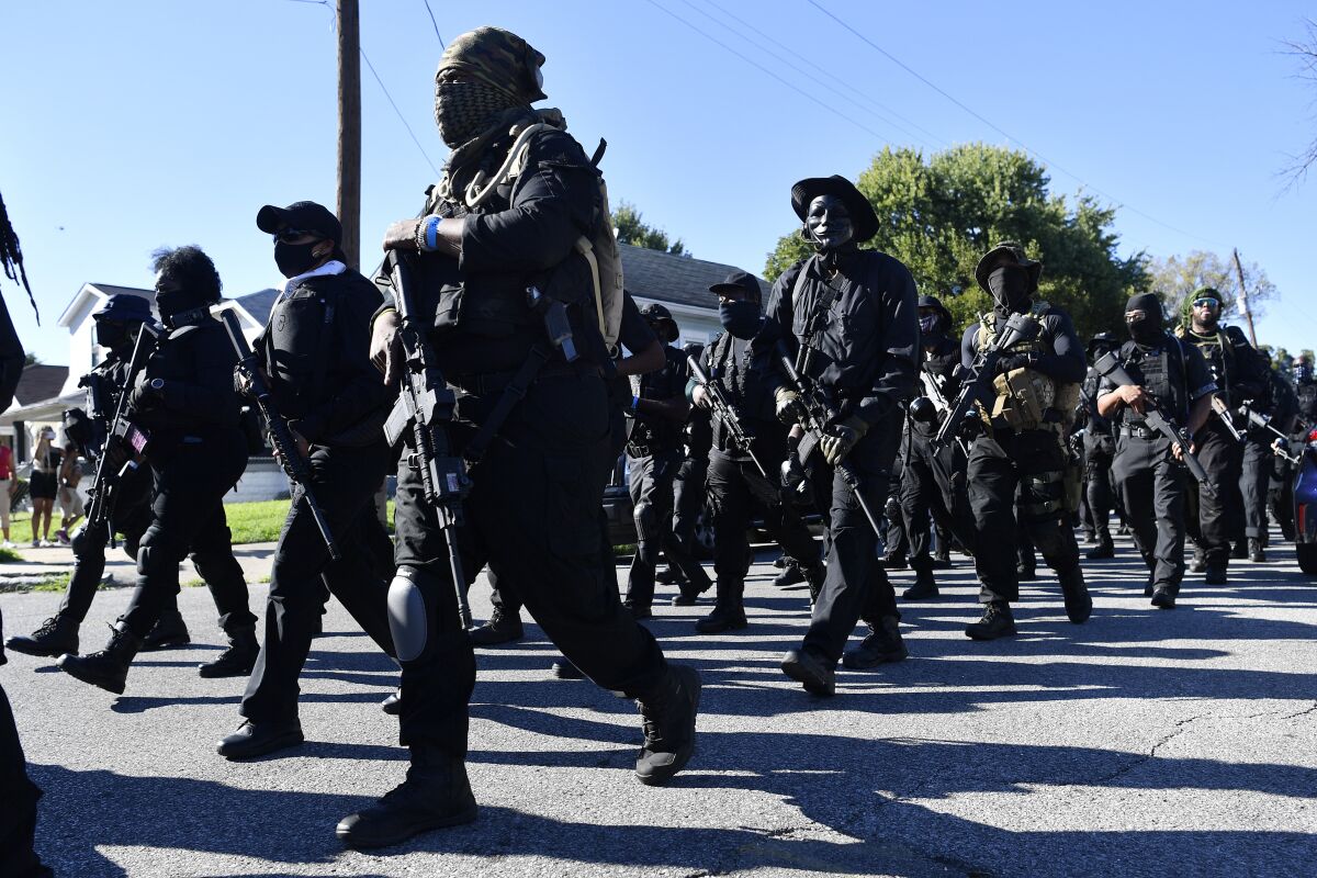 Members of the NFAC, a Black militia, march to Churchill Downs racetrack before the 146th running of the Kentucky Derby, in Louisville, Ky., Saturday, Sept. 5, 2020. (AP Photo/Timothy D. Easley)