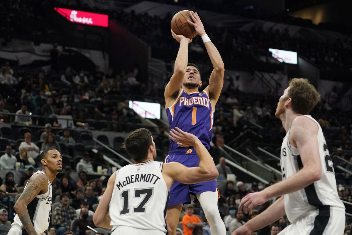 Phoenix Suns guard Devin Booker (1) shoots against the San Antonio Spurs during the second half of an NBA basketball game, Monday, Jan. 17, 2022, in San Antonio. (AP Photo/Eric Gay)