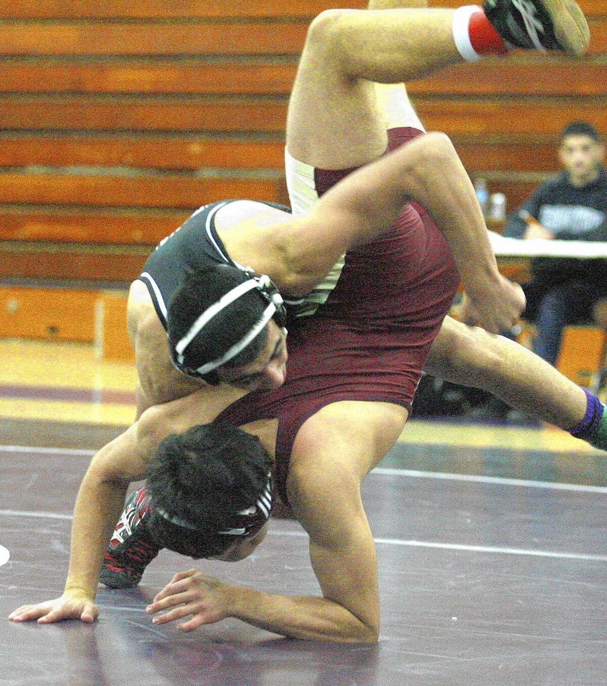 File Photo: Hoover High School's Arthur Ghukasyan flips and eventually pins La Cañada's Chris Harb in the 145-pound weight class in a non-league wrestling match at Hoover High School in Glendale on Tuesday, Jan. 29, 2013.