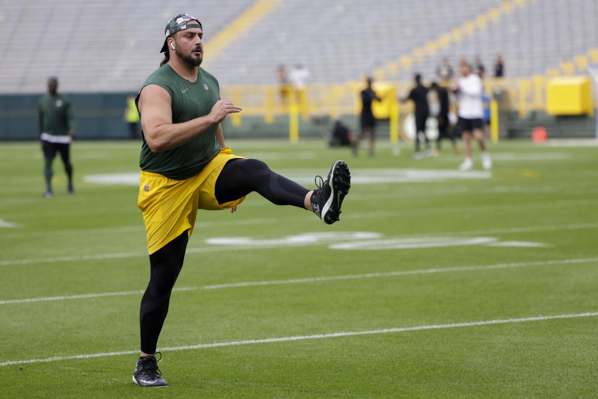 Green Bay Packers' David Bakhtiari stretches before a preseason NFL football game against the New Orleans Saints Friday, Aug. 19, 2022, in Green Bay, Wis. (AP Photo/Mike Roemer)