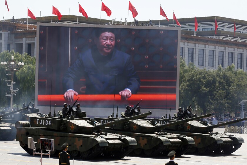 FILE - Chinese President Xi Jinping is displayed on a screen as Type 99A2 Chinese battle tanks take part in a parade commemorating the 70th anniversary of Japan's surrender during World War II, held in front of Tiananmen Gate in Beijing on Thursday, Sept. 3, 2015. From the military suppression of Beijing’s 1989 pro-democracy protests to the less deadly crushing of Hong Kong’s opposition four decades later, China’s long-ruling Communist Party has demonstrated a determination and ability to stay in power that is seemingly impervious to Western criticism and sanctions. (AP Photo/Ng Han Guan, File)