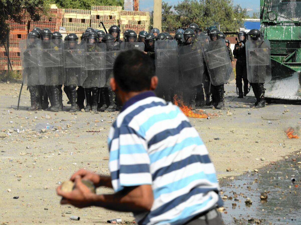 An Algerian man clashes with security forces in Raffour, southeast of Algiers, the capital, during a protest against the presidential elections on April 17, 2014.