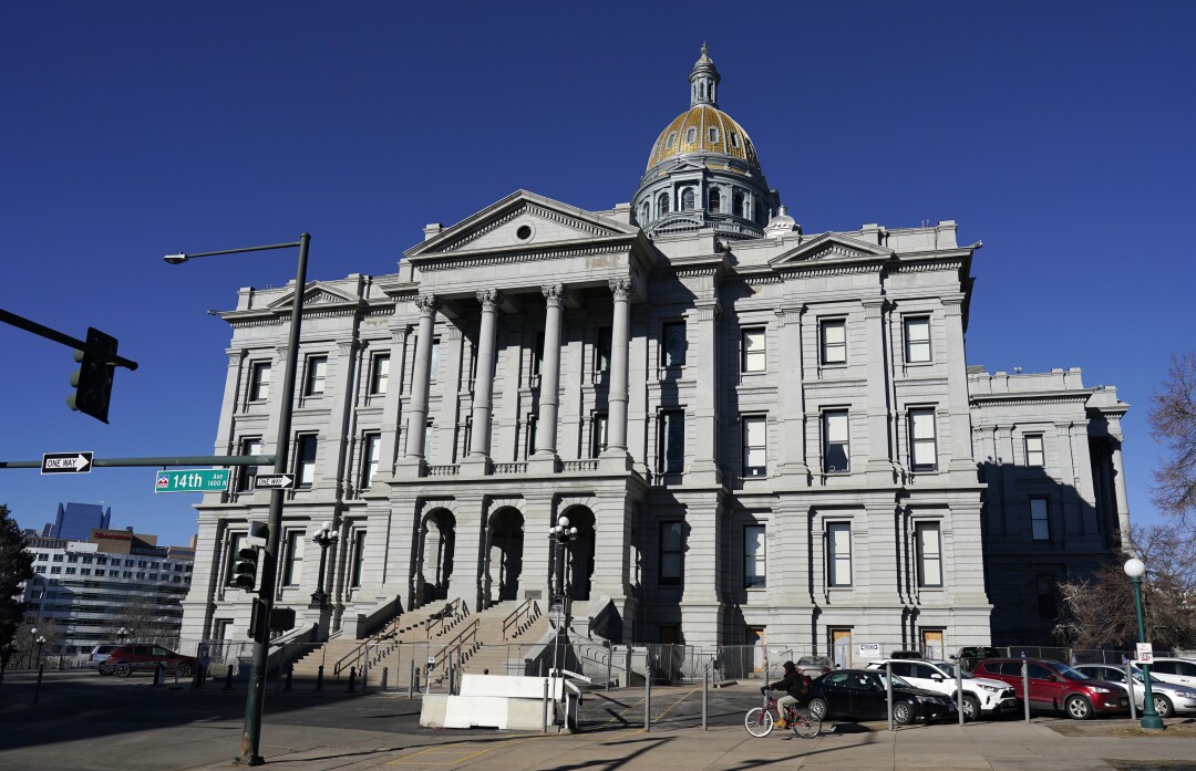Un ciclista passa accanto al Campidoglio del Colorado a Denver.