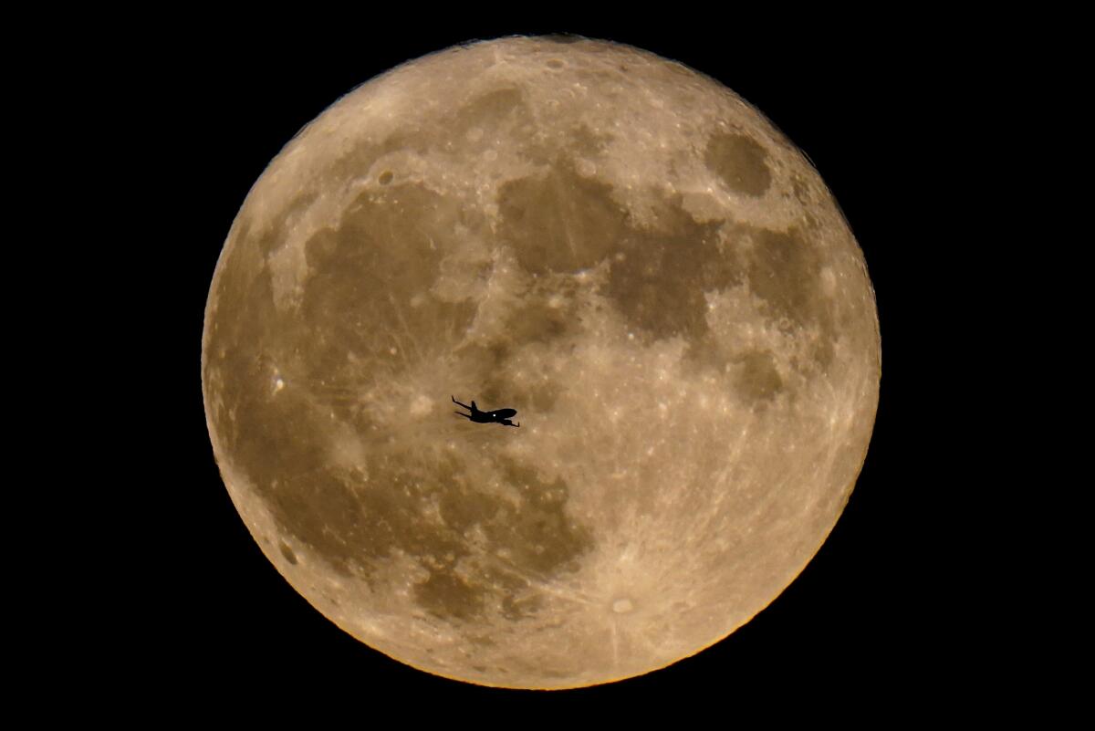 ARCHIVO - Un avión pasa frente a una superluna, el 13 de julio de 2022,