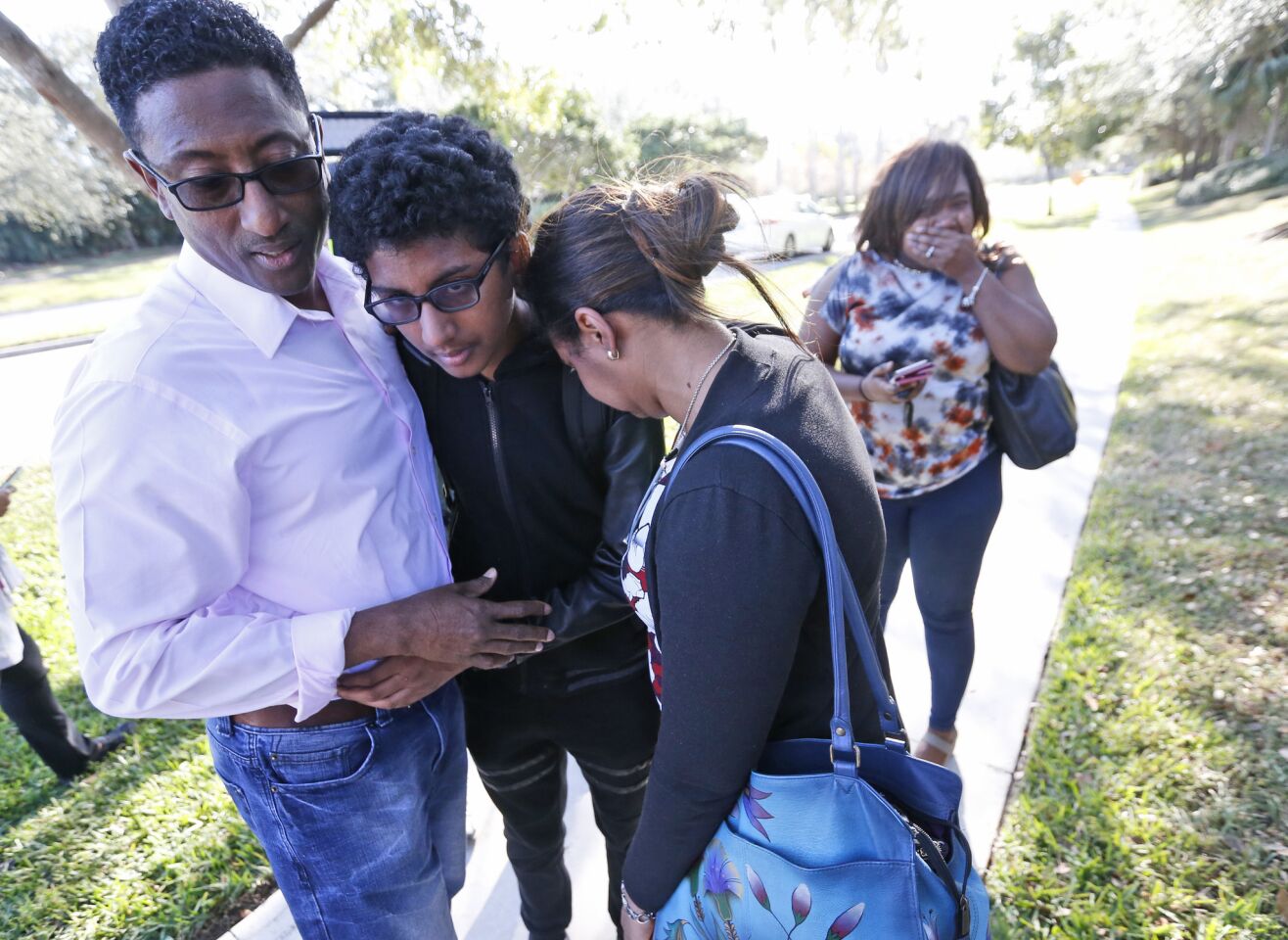 Family members embrace a student who was released from the school. A shooting at the school sent students rushing into the streets as SWAT team members swarmed in and locked down the building.