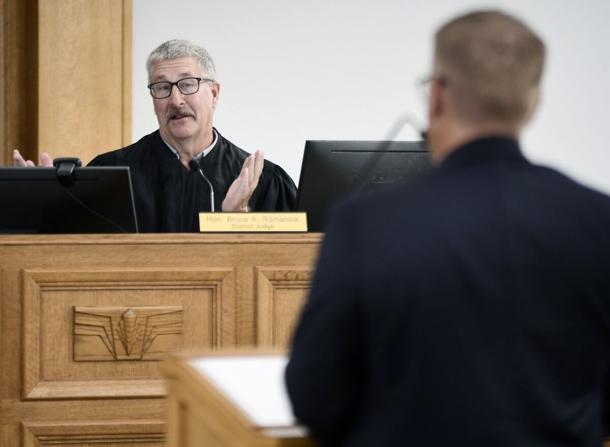 South Central District Judge Bruce Romanick, left, asks a question to Matthew Sagsveen, representing the North Dakota Attorney General's office, during a preliminary injunction hearing on Friday, Aug. 19, 2022, in Bismarck, N.D., on whether to block the state's trigger law banning nearly all abortions. (Mike McCleary/The Bismarck Tribune via AP)