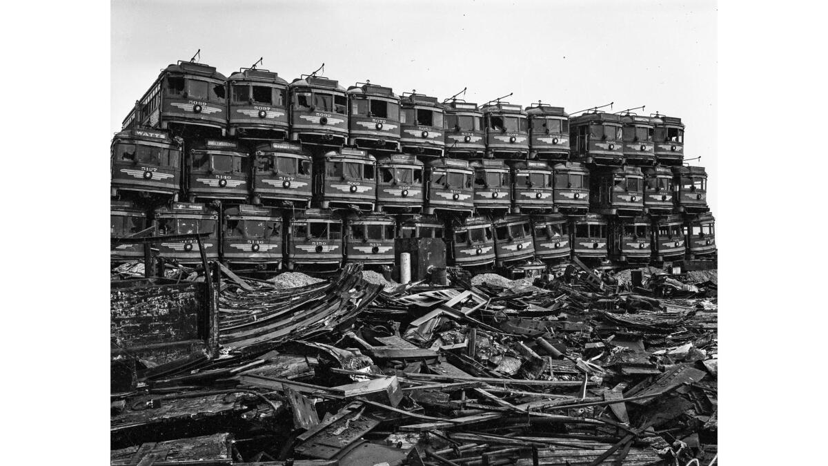 streetcars are stacked four high in a junkyard