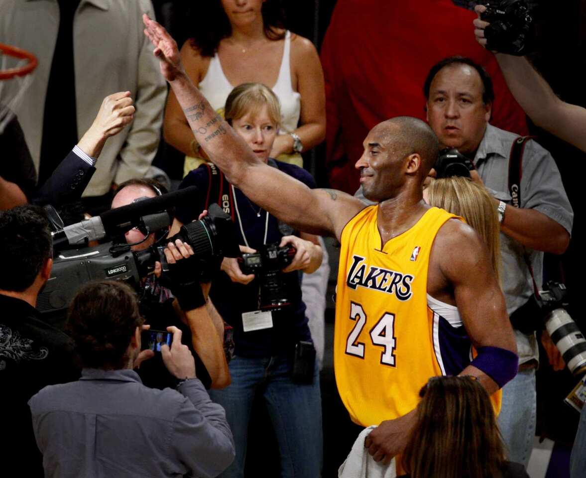 Guard Kobe Bryant gets a high-five from a fan after the Lakers defeated the Nuggets, 96-87, in Game 7 of their first-round playoff series on Saturday night at Staples Center.