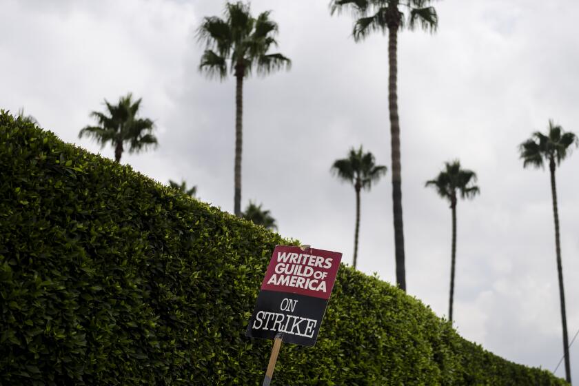 FILE - A demonstrator holds up a sign during a rally outside the Paramount Pictures Studio in Los Angeles, Thursday, Sept. 21, 2023. On Sunday, Sept. 24, 2023, a tentative deal was reached to end Hollywood’s writers strike after nearly five months. (AP Photo/Jae C. Hong, File)