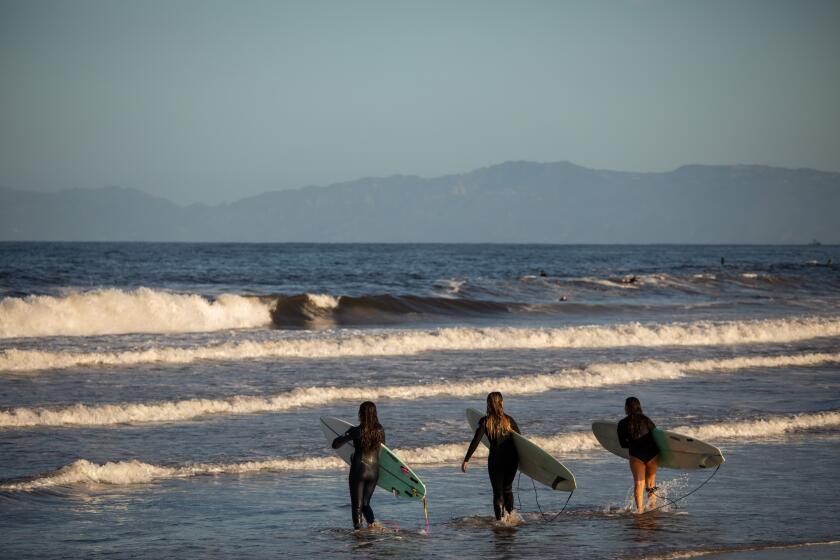 HERMOSA BEACH, CA - MAY 13: Three surfers came out to Hermosa Beach, CA, as Los Angeles County beaches re-open Wednesday, May 13, 2020, during the coronavirus pandemic. (Jay L. Clendenin / Los Angeles Times)