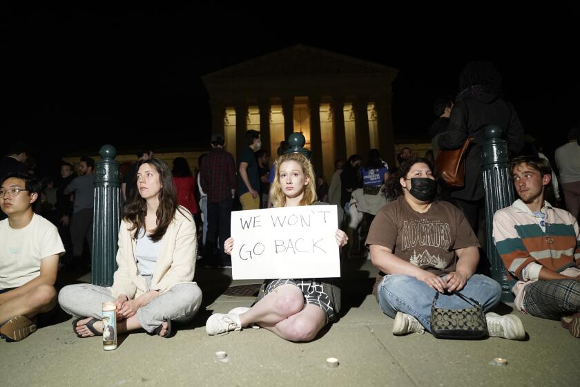 Libby Kernahan, center, gathers outside the Supreme Court on Monday night