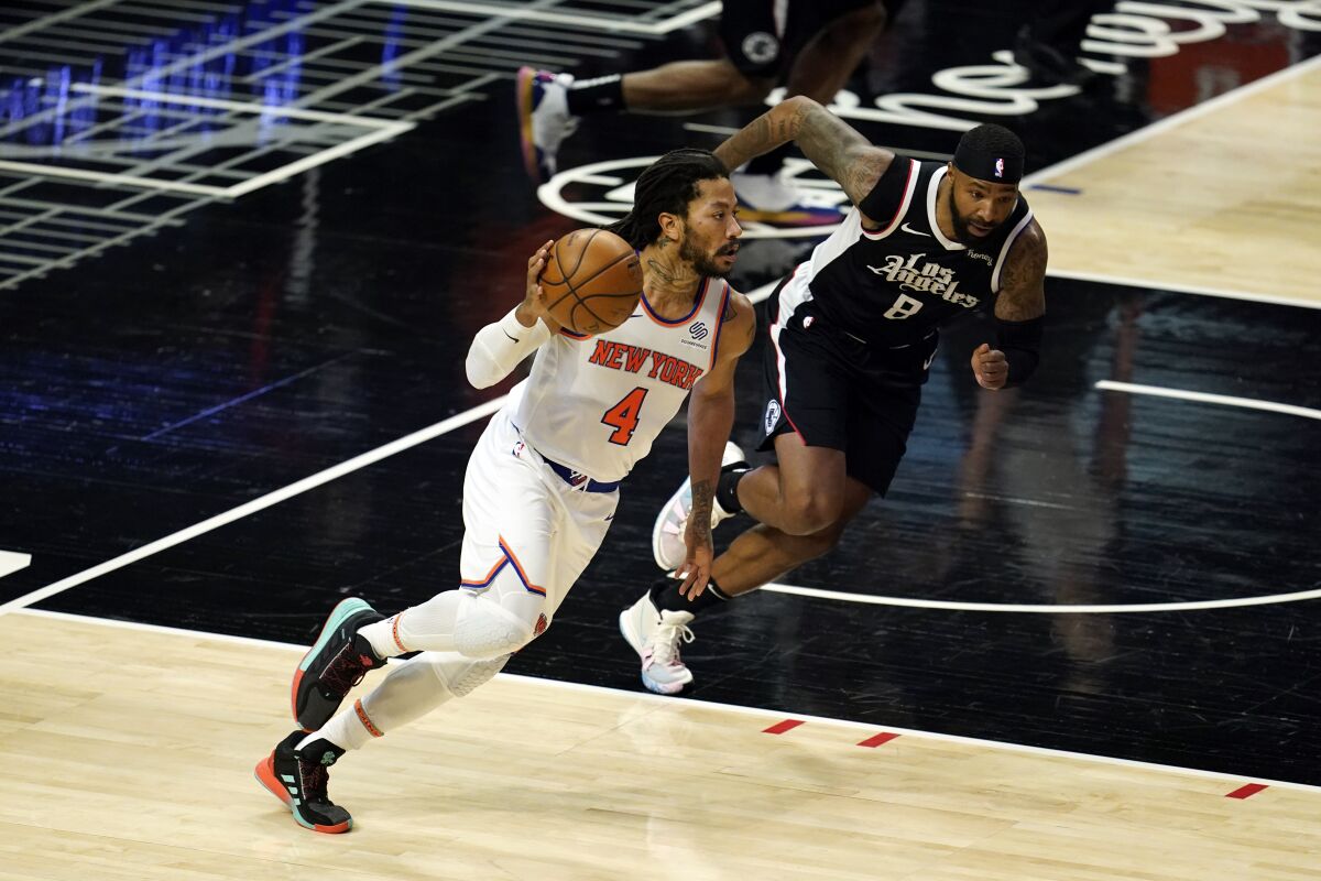 Derrick Rose dribbles past Marcus Morris during the first half.