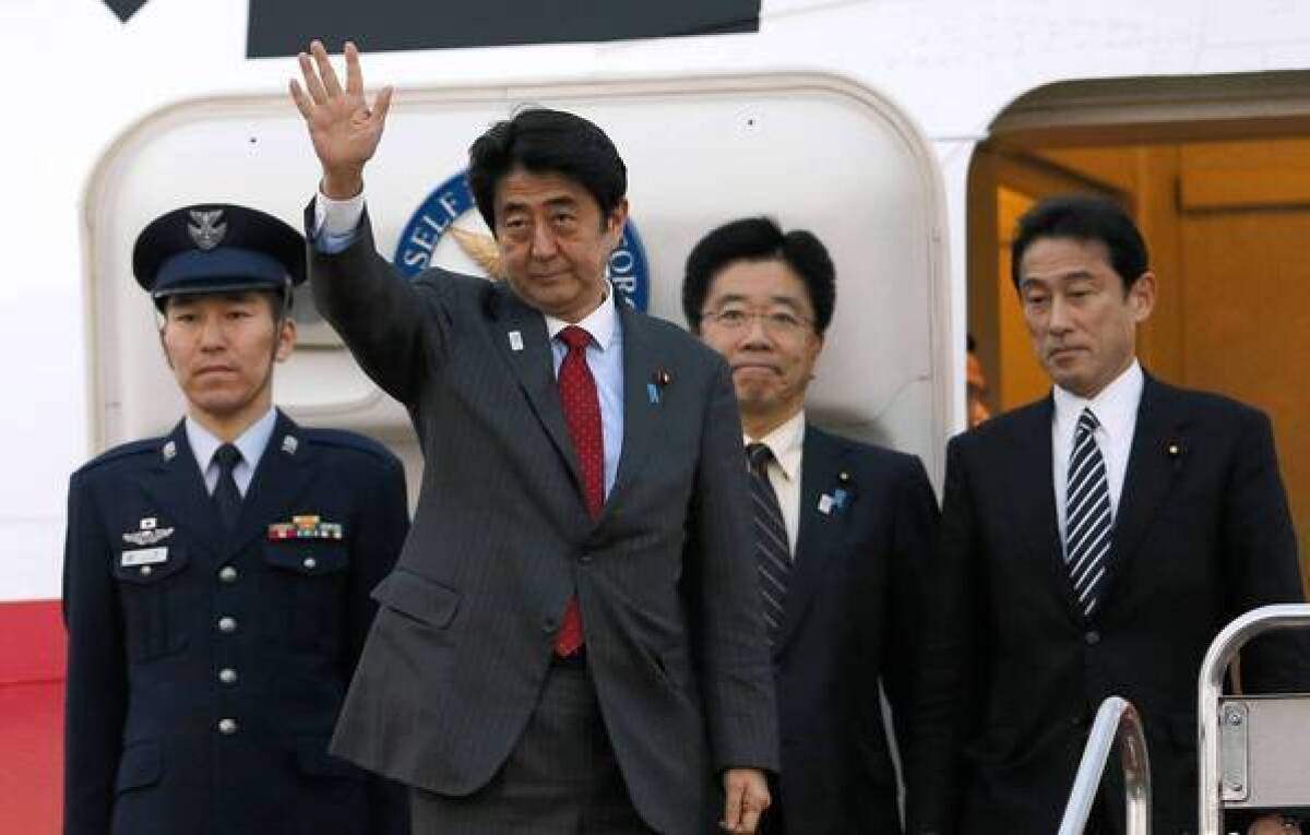 Japanese Prime Minister Shinzo Abe waves in Tokyo as he prepares to board a flight to Washington. He and President Obama will hold talks Friday.