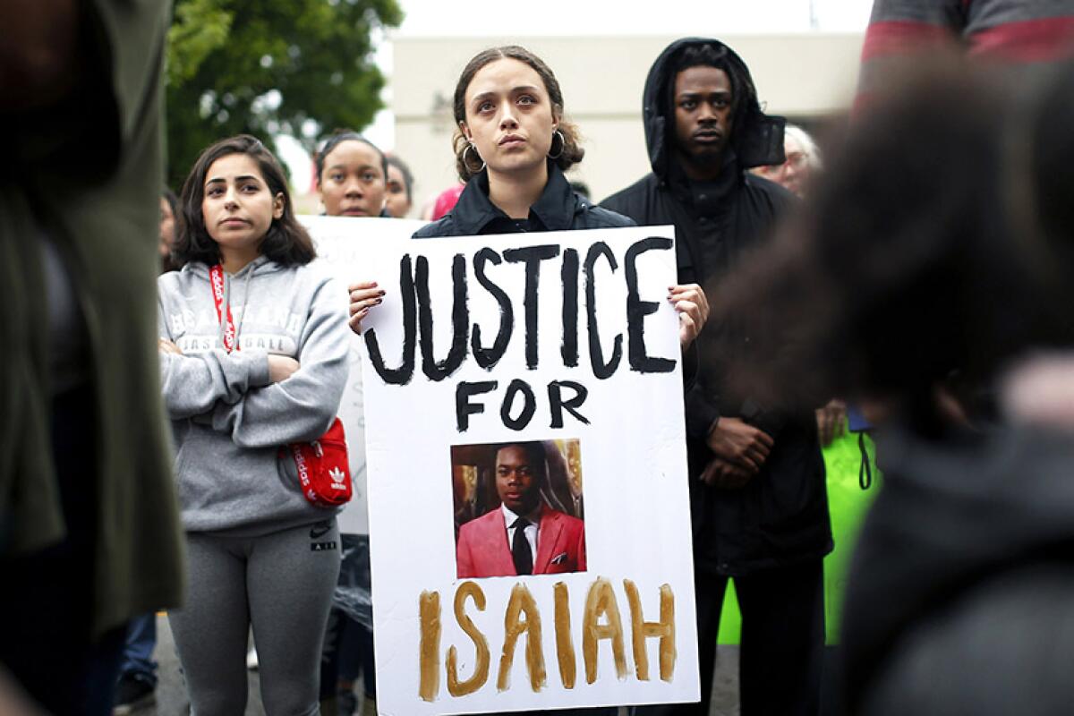 A sign featuring a photo of Isaiah Mark Lewis is displayed during a protest at the Edmond, Okla., Police Department on May 3. Lewis, 17, was fatally shot by police on April 29.