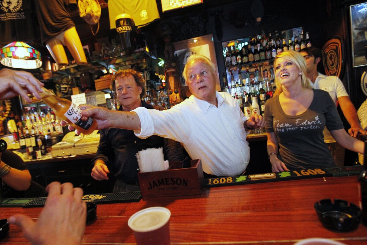 In this Aug. 23, 2011, photo, former Louisiana Governor Edwin Edwards, 84, and his wife Trina Scott Edwards, 32, right, serve as honorary bartenders at Molly's On The Market Bar during a Press Club of New Orleans function in New Orleans. Edwin Washington Edwards, the high-living four-term governor whose three-decade dominance of Louisiana politics was all but overshadowed by scandal and an eight-year federal prison stretch, died Monday, July 12, 2021 . He was 93. Edwards died of respiratory problems with family and friends by his bedside, family spokesman Leo Honeycutt said. He had suffered bouts of ill health in recent years and entered hospice care this month at his home in Gonzales, near the Louisiana capital. (AP Photo/Gerald Herbert)