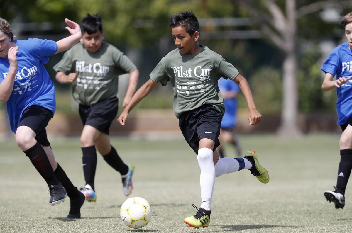 Killybrooke Elementary's Carlos Alcala advances the ball against Lincoln during a boys’ fifth- and sixth-grade Gold Division pool-play match at the Daily Pilot Cup on Wednesday at Jack R. Hammett Sports Complex.