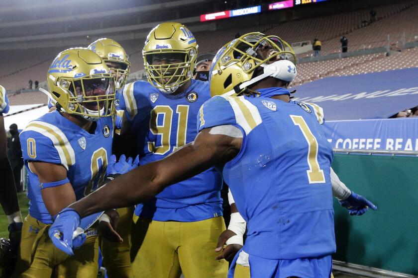 UCLA quarterback Dorian Thompson-Robinson (1) celebrate a touchdown with teammates during the second half of an NCAA college football game against the Stanford Saturday, Dec. 19, 2020, in Pasadena, Calif. Stanford won 48-47 in overtime. (AP Photo/Ringo H.W. Chiu)