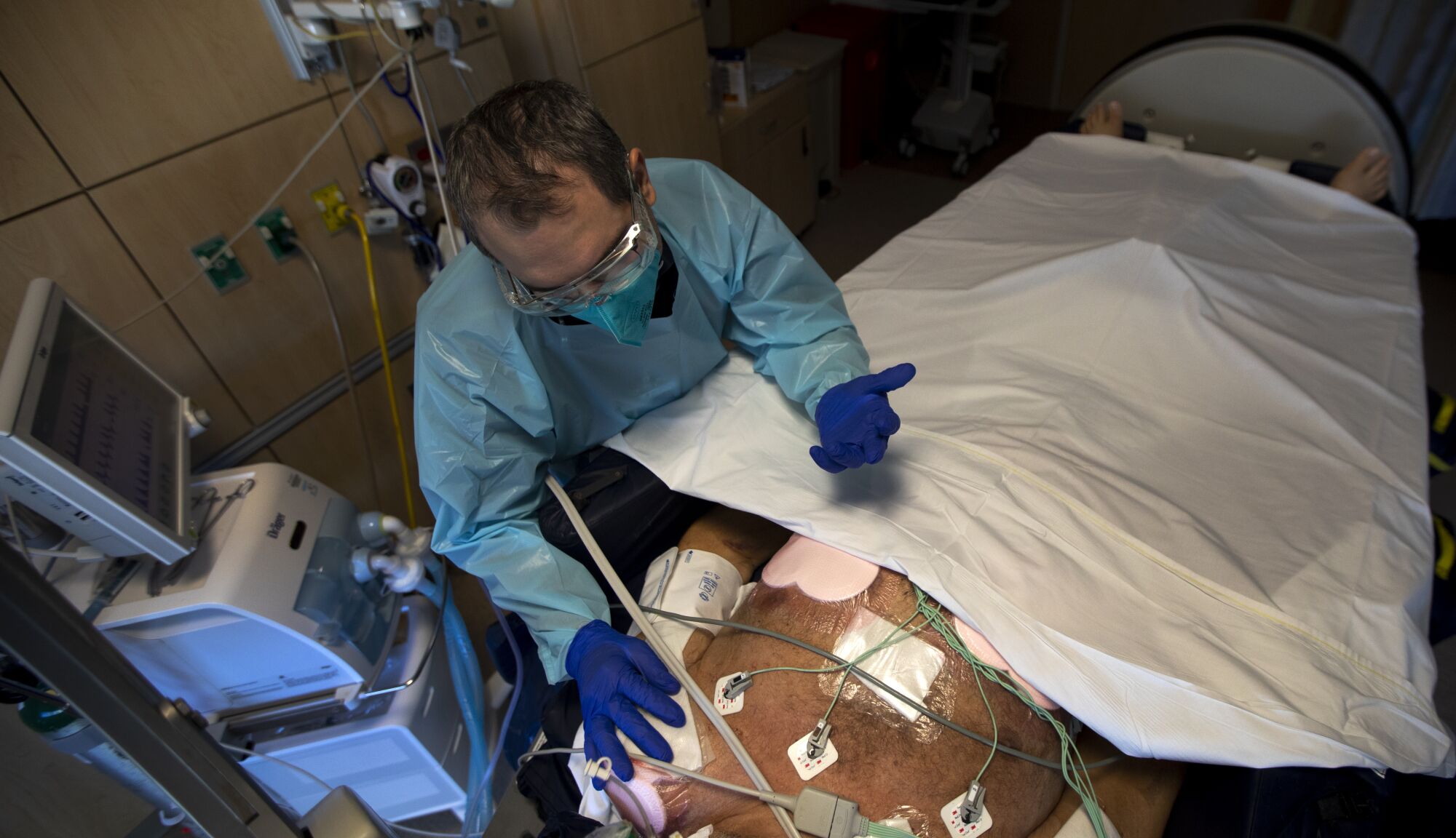 Chaplain Kevin Deegan prays over patient Bob Harris.