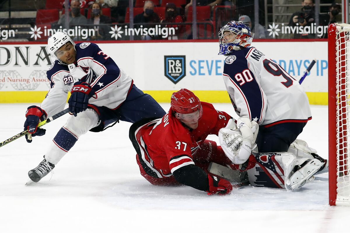 Carolina Hurricanes' Andrei Svechnikov (37) collides with Columbus Blue Jackets' Seth Jones (3) and goaltender Elvis Merzlikins (90) after losing control of the puck during the second period of an NHL hockey game in Raleigh, N.C., Saturday, May 1, 2021. (AP Photo/Karl B DeBlaker)