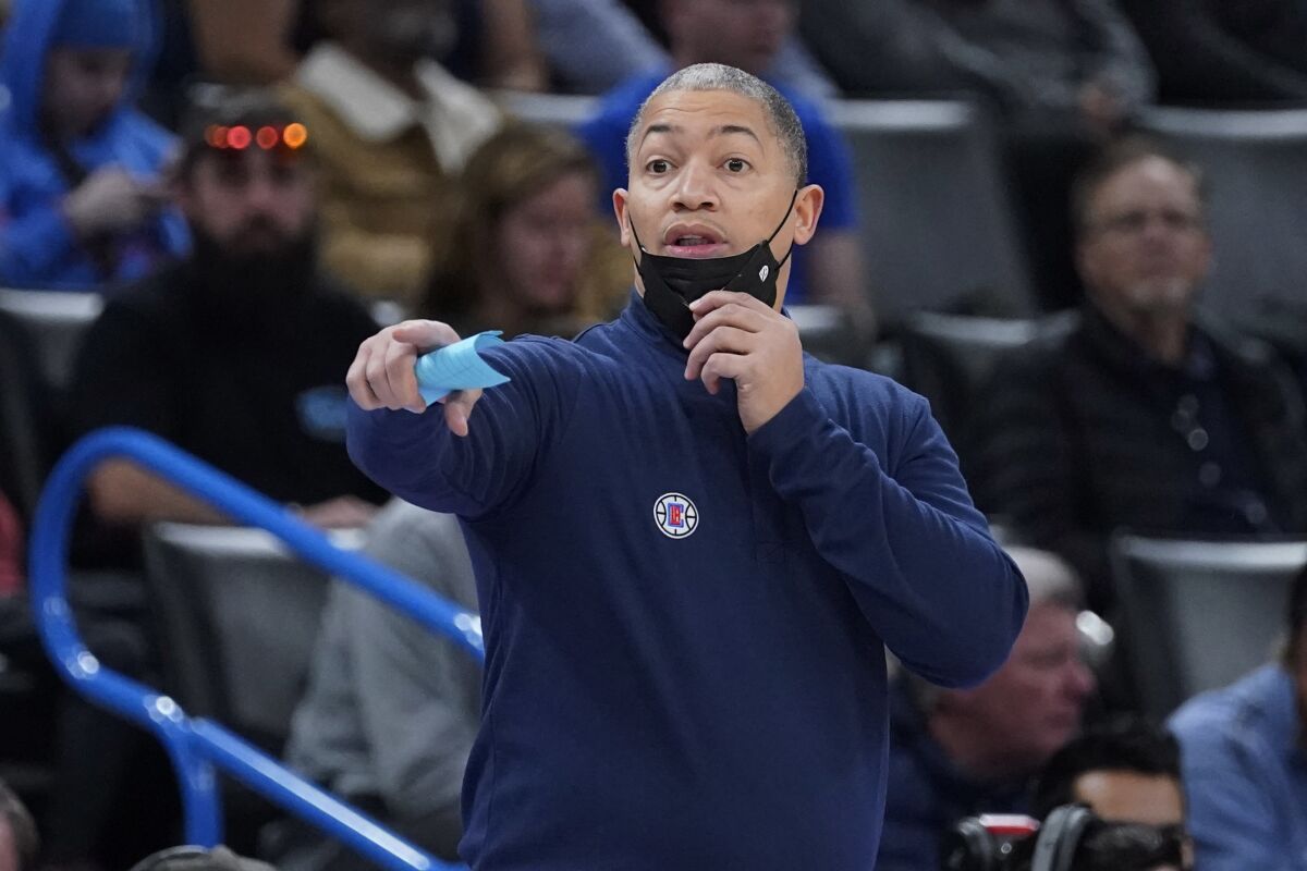 Los Angeles Clippers head coach Tyronn Lue pulls his mask down to direct his team in the first half.