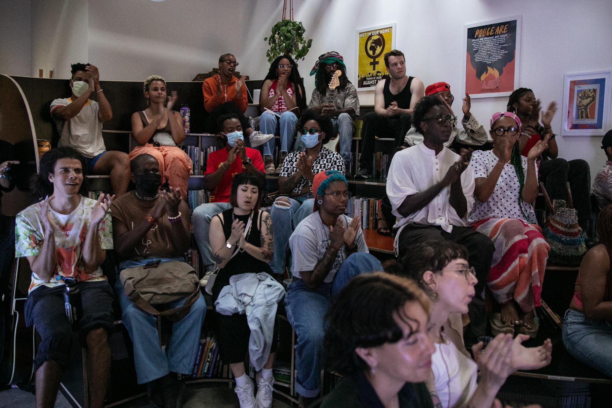 The crowd claps for performers at a bookstore