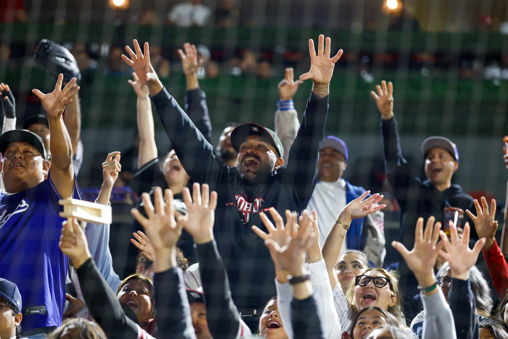 Tijuana Toros fans scream for a baseball during Saturday's game.