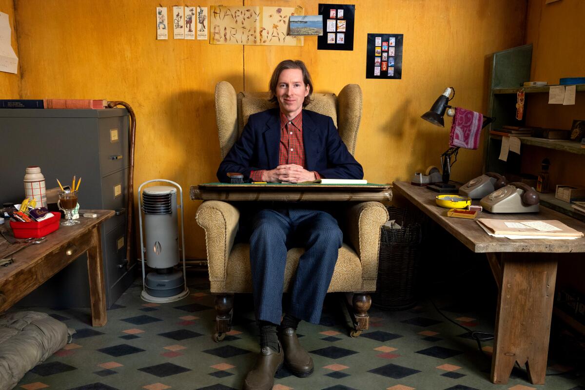 Writer-director Wes Anderson sits in a wing-back chair on the set of "The Wonderful Story of Henry Sugar."
