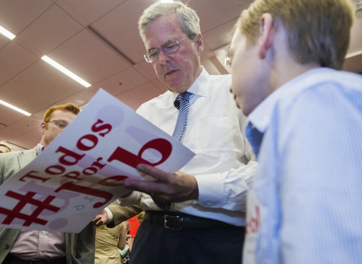 Republican presidential candidate, former Florida Gov. Jeb Bush, autographs campaign literature for a young supporter after speaking at the Florida State University Conference Center in Tallahassee, Fla., Monday, July 20, 2015. (AP Photo/Mark Wallheiser)