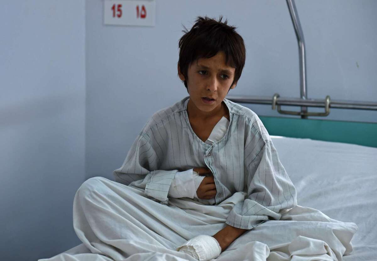A wounded Afghan boy, survivor of the U.S. airstrikes on a hospital in Kunduz, sits on his bed at an Italian aid organization hospital in Kabul on Oct. 6.