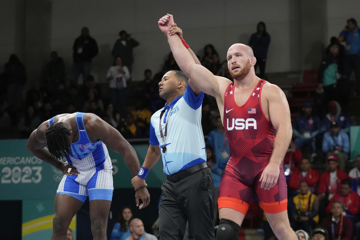 Kyle Snyder of the United States, right, celebrates after winning gold against Cuba's Arturo Silot, left, during the men's 97kg wrestling freestyle final bout at the Pan American Games Santiago, Chile, Wednesday, Nov. 1, 2023. (AP Photo/Matias Delacroix)