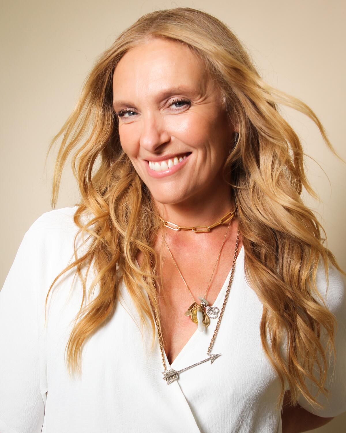 A portrait of Toni Collette, wavy long hair flowing over her shoulders.