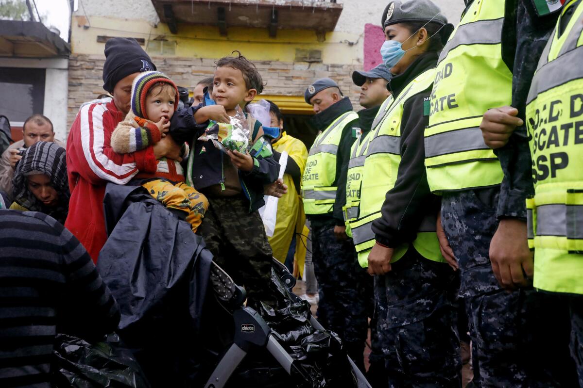 Hunger striker Rosa Dubon of Honduras, with children Daniel Dubon, 2, and Josue Dubon, 4, and others with the migrant caravan are blocked by Mexican federal police from marching to the Chaparral port of entry in Tijuana on Nov. 29, 2018.