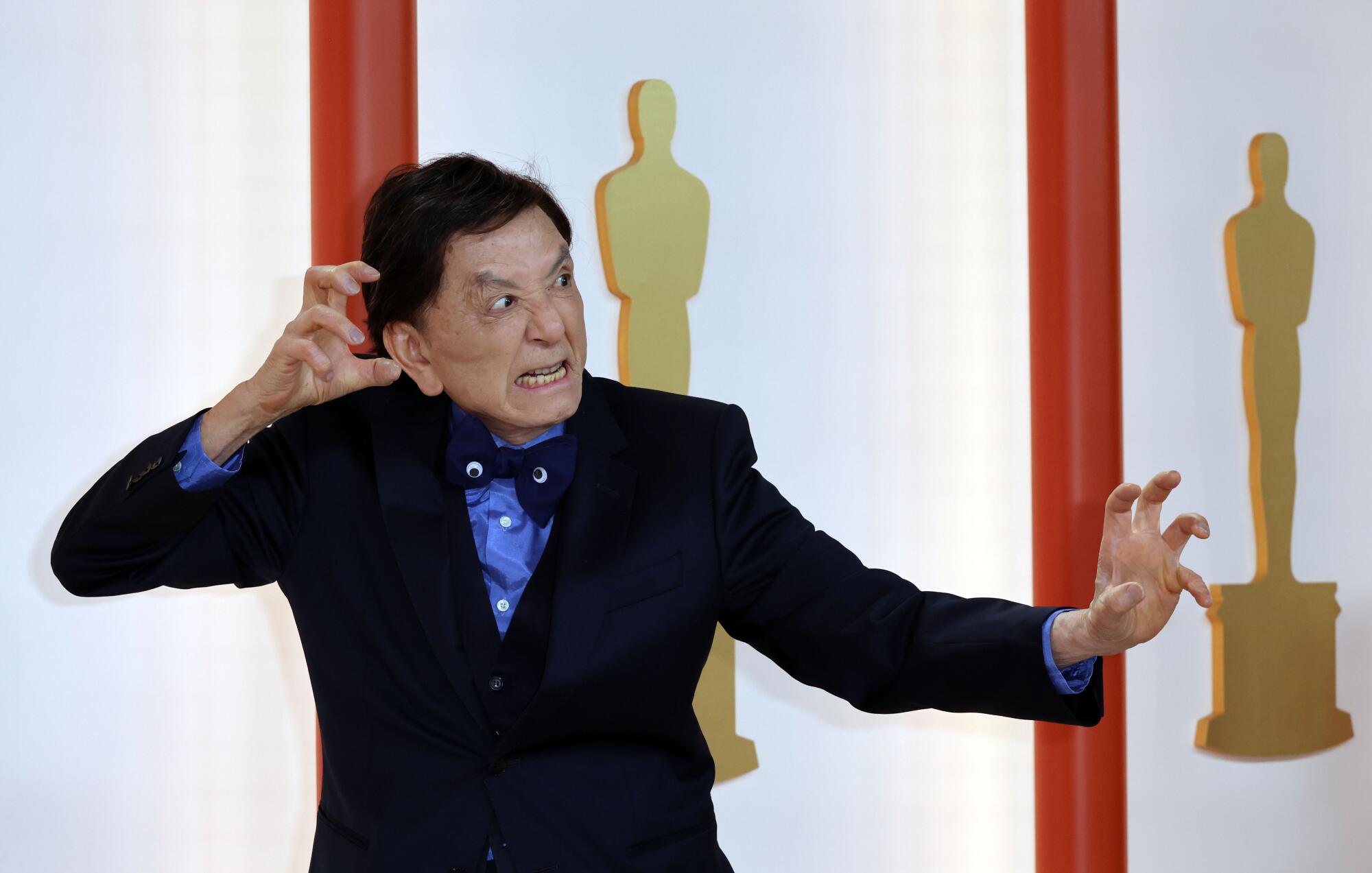 James Hong, in a black tux, with googly eyes on his bow tie, assumes an aggressive martial arts pose.