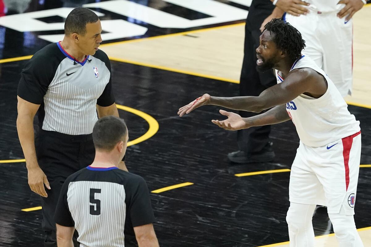 The Clippers' Patrick Beverley shows officials blood on his hand after he was called for a foul while defending Devin Booker.