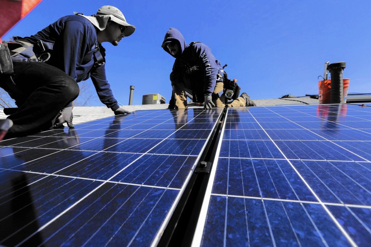 Workers from Sunrun, a residential solar company, install a solar system at a home in Van Nuys.