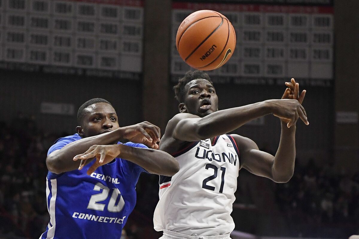 Central Connecticut State's Stephane Ayangma, left, and Connecticut's Adama Sanogo reach for the ball in the second half of an NCAA college basketball game, Tuesday, Nov. 9, 2021, in Storrs, Conn. (AP Photo/Jessica Hill)