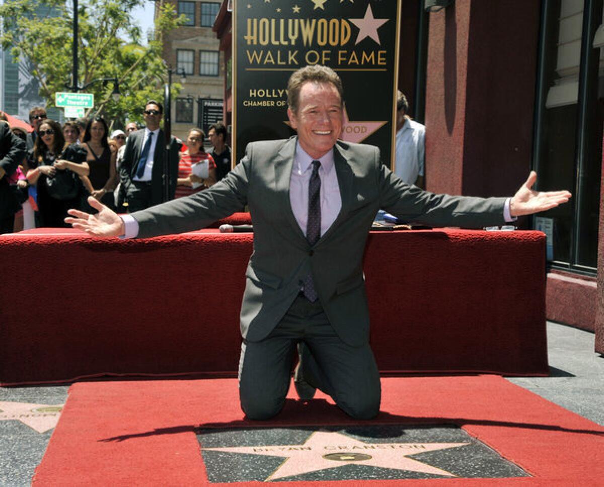 Actor Bryan Cranston poses atop his new star on the Hollywood Walk of Fame...wearing more than his underwear.