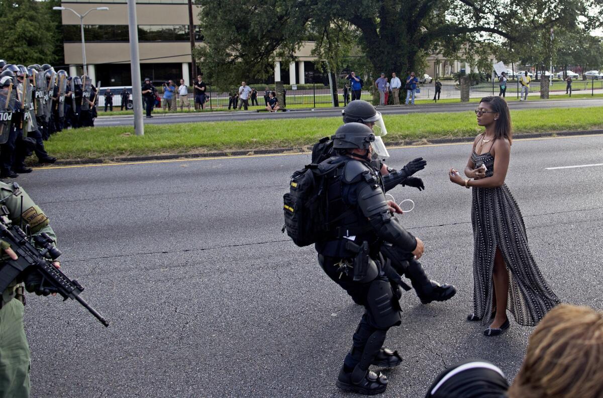 Policías armados y con equipo antidisturbios detienen a una manifestante que rehúsa retirarse de una carretera frente a la Estación del Departamento de Policía de Baton Rouge, en Louisiana, el sábado 9 de julio de 2016. (AP Foto/Max Becherer)