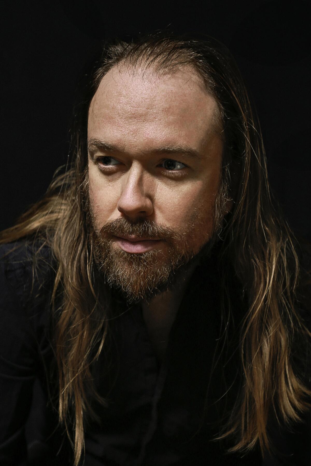 Portrait of long-haired man looking away from camera