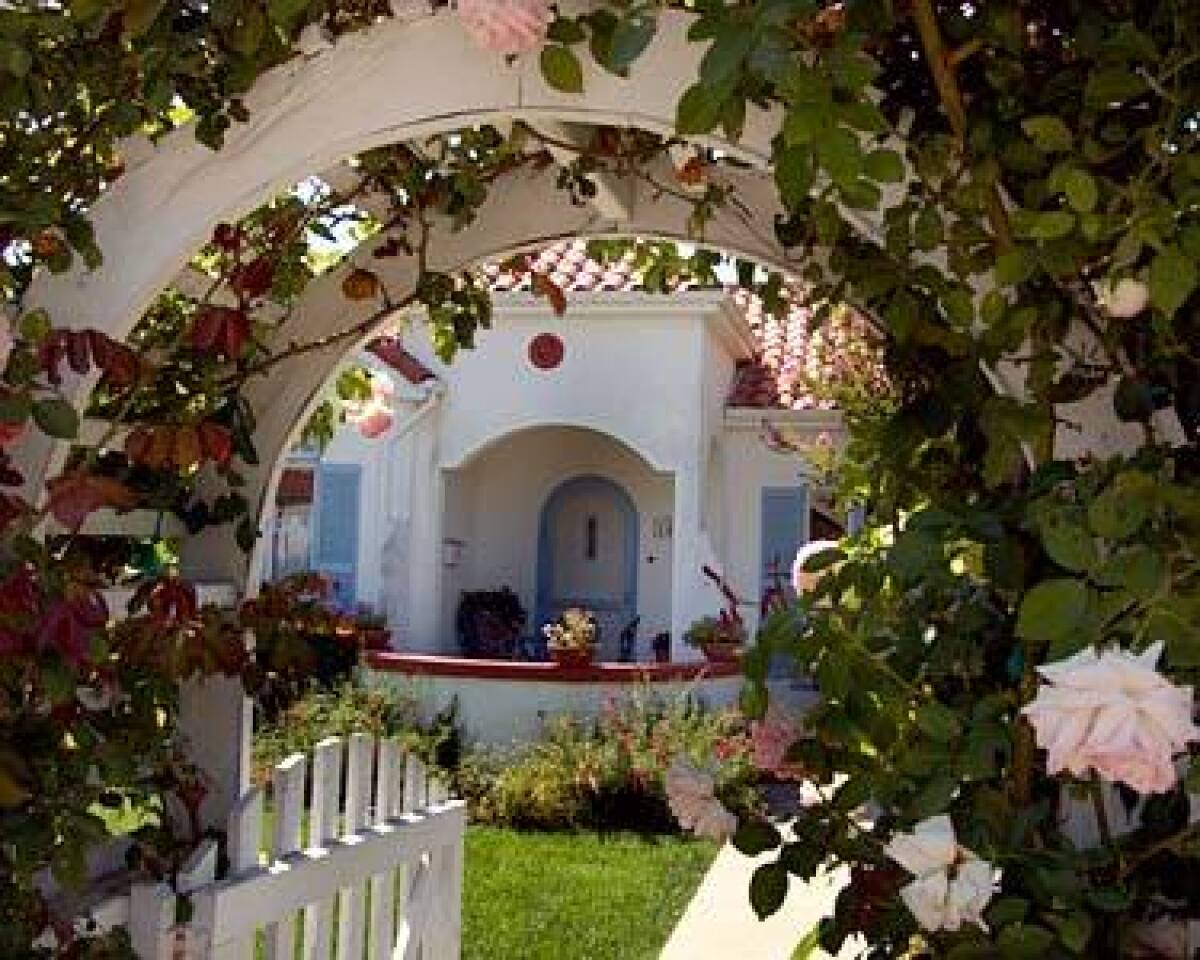 Red-tiled roofs and cream-colored stucco of 1920s Spanish-style homes are interspersed with Craftsman bungalows on shady streets.